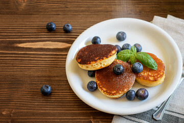 Traditional japanese fluffy pancakes with blueberries and sprinkled with sugar powder. Delicious breakfast on the white plate.