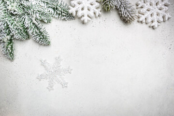 Christmas holidays composition with snowed fir tree branches and snowflakes on white background with copy space for your text