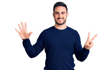 Fototapeta premium Young handsome man wearing casual clothes showing and pointing up with fingers number seven while smiling confident and happy.
