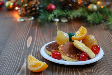 Obraz na płótnie Canvas Traditional japanese fluffy pancakes with glazed fruits on the Christmas background. Nice delicious breakfast one festive morning.
