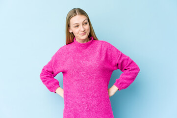 Young blonde woman isolated on blue background dreaming of achieving goals and purposes