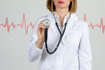 Young female doctor cardiologist pointing stethoscope with heart treatment concept isolated on white.