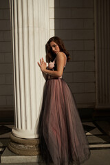 Young beautiful woman in an evening dress in the theater