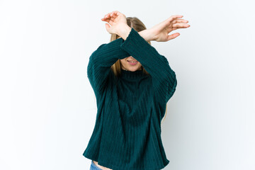Young blonde woman isolated on white background keeping two arms crossed, denial concept.