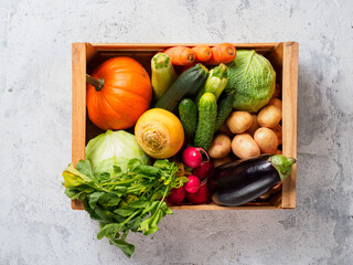 Box with vegetables on gray background.