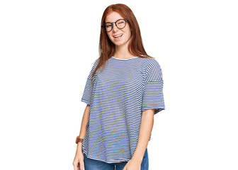 Young read head woman wearing casual clothes and glasses winking looking at the camera with sexy...