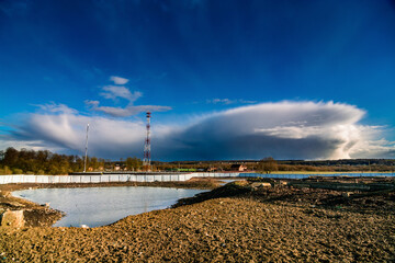 farm pond and cumulonimbus clouds in the evening