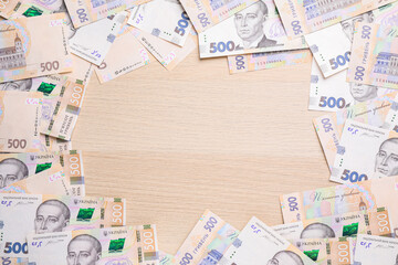 Frame of Ukrainian money on wooden background, flat lay. Space for text