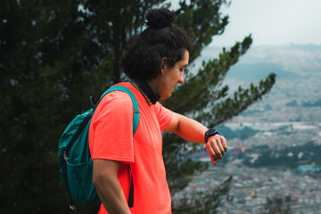 Fototapeta premium Man in the forest looking his watch and hiking