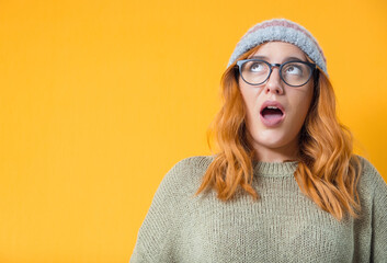 Surprised beautiful woman stare up , isolated on yellow background. Surprise expression face - head...