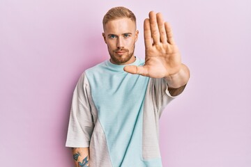 Young caucasian man wearing casual clothes doing stop sing with palm of the hand. warning...