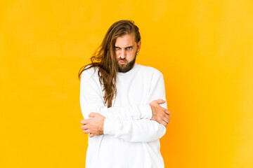 Young man with long hair look blows cheeks, has tired expression. Facial expression concept.