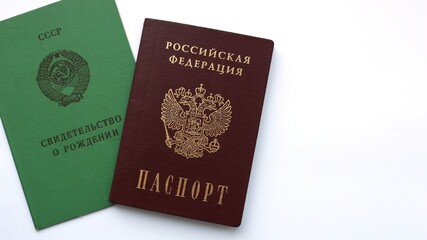 documents with the inscription "USSR Birth Certificate" and "Russian Federation Passport" placed together on a clean white background with space for text top view