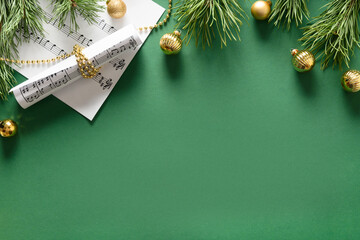 Music Christmas composition for Carols and songs decorated golden balls on green background. View...