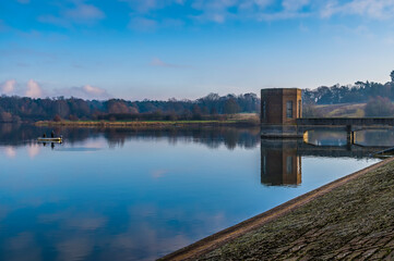 A view from the barrage of reflections along the shoreline of Pitsford Reservoir, UK in winter