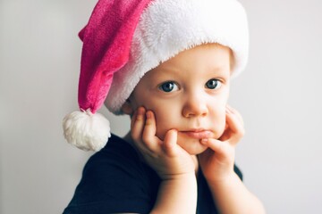 Little cute child wearing Santa's hat. Portrait of a Santa. New year 2021. - 397889856