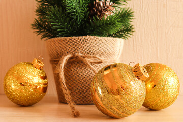 Festive New Year or Christmas background with golden christmas balls and Christmas tree in a pot. Close-up