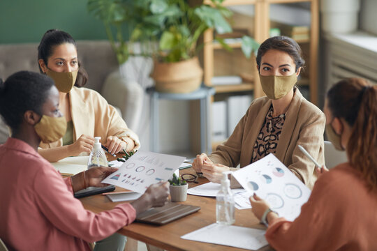 High Angle View At Multi-ethnic Group Of Young Businesswomen Wearing Masks During Meeting In Office, Copy Space