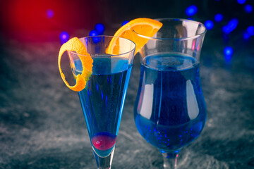 Traditional cocktail volcano with blue curacao and champaign offered as close-up in design glasses