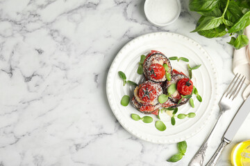 Baked eggplant with tomatoes, cheese and basil served on white marble table, flat lay. Space for text