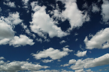 Dark blue sky with white clouds and half moon