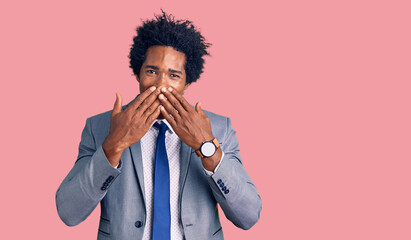 Handsome african american man with afro hair wearing business jacket laughing and embarrassed...