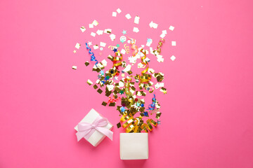 Box with bright confetti on pink background, flat lay