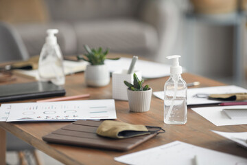 Background image of wooden meeting table with documents, masks and hand sanitizer in office, copy space