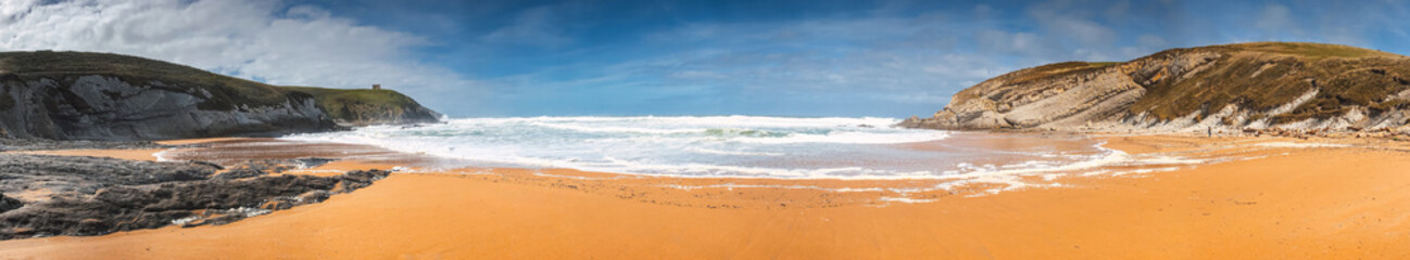 Fototapeta na wymiar Panoramic view of the beach coast on a sunny day with big cliffs