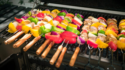 Chef cooking barbecue with skewers on grilled meat. Very delicious brochette BBQ