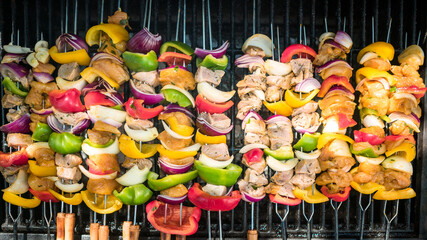Chef cooking delicious skewers on the BBQ grill. Cook brochette on grilled meat