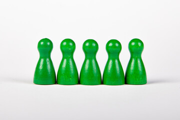 five green wooden figurines in a row on white background