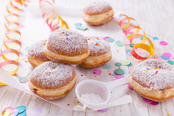 Traditional Berliner for carnival and party. German Krapfen or donuts with streamers and confetti....