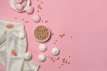 Chickpea seeds, white and pink meringues on a pink background, top view with space