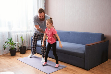 Girl and her father doing gymnastic exercise