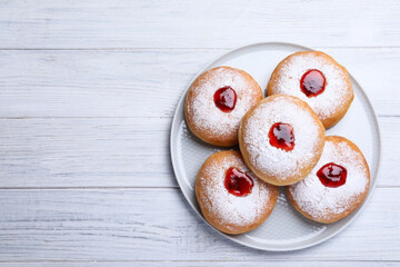 Hanukkah doughnuts with jelly and sugar powder on white wooden table, top view, Space for text