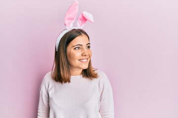 Young beautiful woman wearing cute easter bunny ears looking away to side with smile on face, natural expression. laughing confident.
