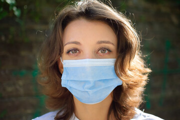 Coronavirus Covid-19 outbreak. Young woman wearing surgical mask on the face for protection from...