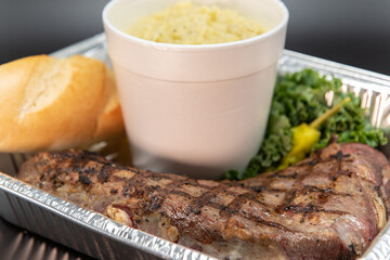 Fresh off the grill whole tritip roast steak with large side of mashed potatoes and bread to feed your whole family