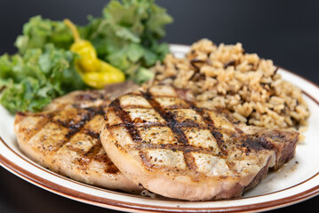 Fresh off the grill pork chops served with all the familiar vegetable and rice sides.