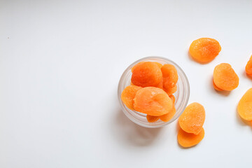 Top view of dry apricots placed around and in of a glass cup