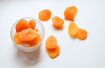 Top view of dry apricots placed around and in of a glass cup