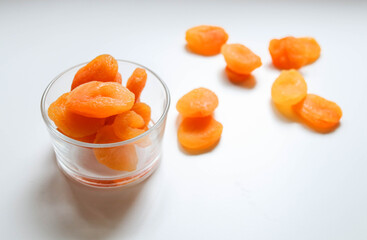 Top view of dry apricots placed around and in of a glass cup