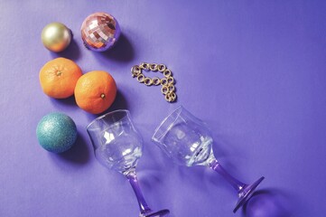 Blue, pink, golden balls, two champagne glasses, mandarins fruits and gift bracelet. Christmas eve flat lay composition photography, New Year holidays atmosphere, winter aesthetics