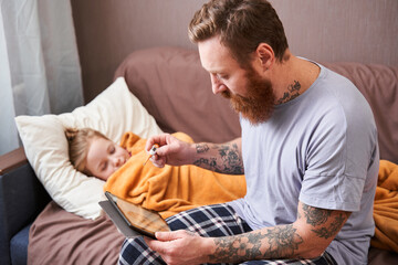 Father sitting near his sick daughter