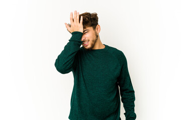 Young arab man on white background forgetting something, slapping forehead with palm and closing...