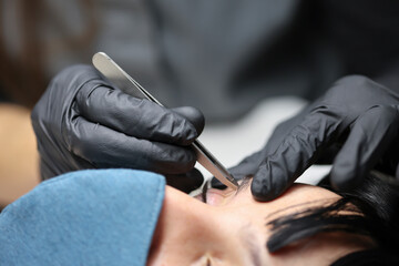 Woman doing her eyebrows in a beautician.