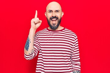 Fototapeta premium Young handsome man wearing casual clothes pointing finger up with successful idea. exited and happy. number one.