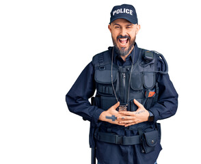 Young handsome man wearing police uniform smiling and laughing hard out loud because funny crazy joke with hands on body.