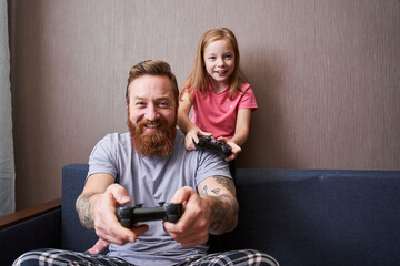 Father and his little cute daughter with gamepads © Yakobchuk Olena